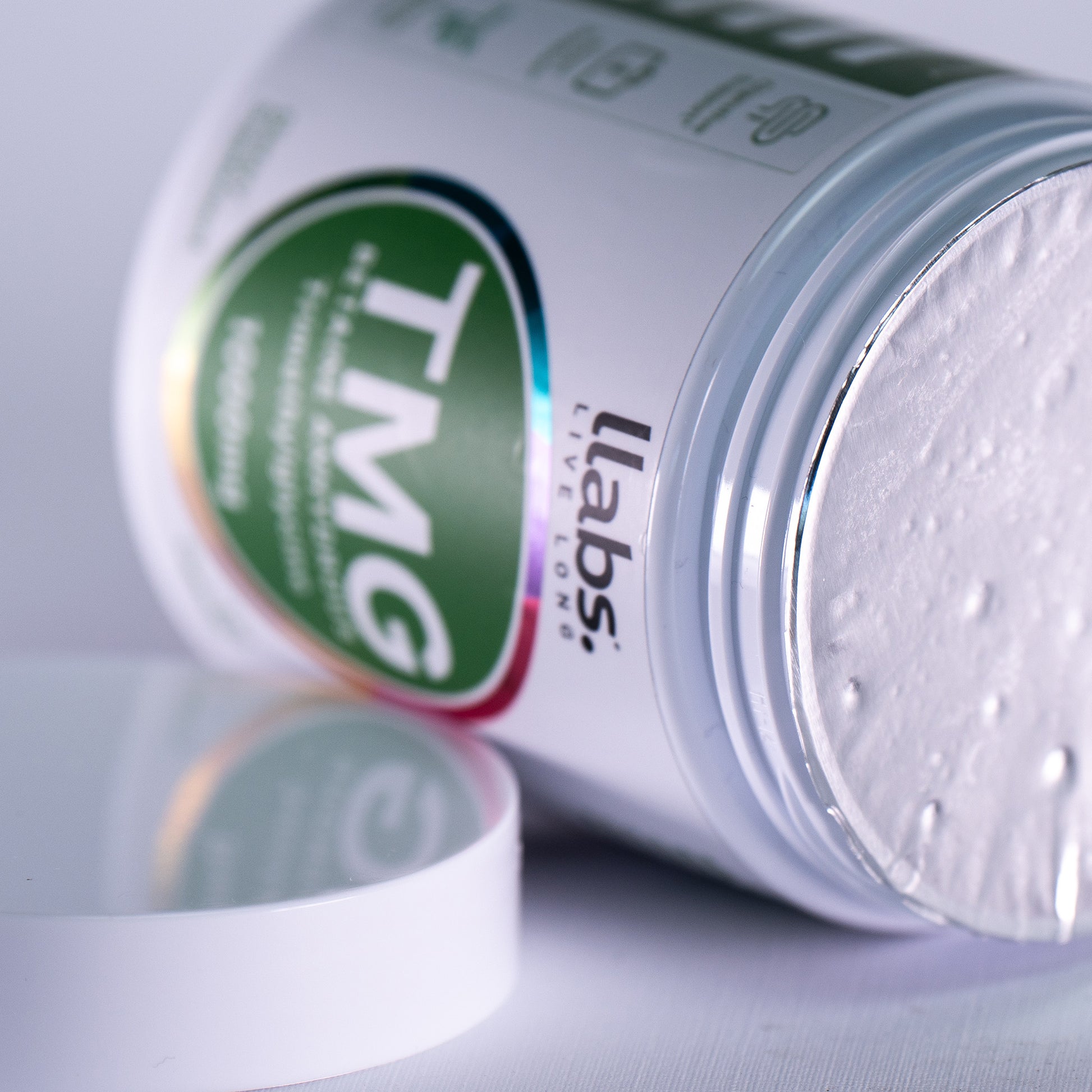 A container of llabs. TMG Supplement (Betaine) with its lid removed, showcasing the product label and white powder inside, ready to elevate your daily routine.